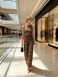 Woman's leopard print two-piece ensemble features a round-neck, sleeveless, irregularly cropped vest paired with flared, wide-leg trousers, presenting an elegant combination suitable for both streetwear and club attire
